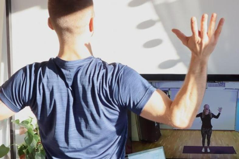 The person has raised their hands in the air and holds their palms together.