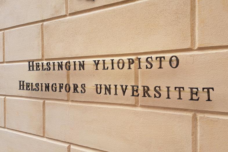 On the yellow brick wall the black text "Helsingin yliopisto, Helsingfors universitet".
