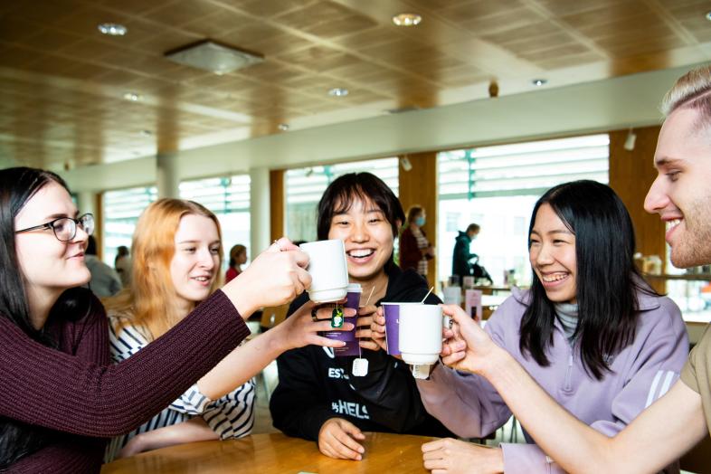 Students cheer with a cups in their hands