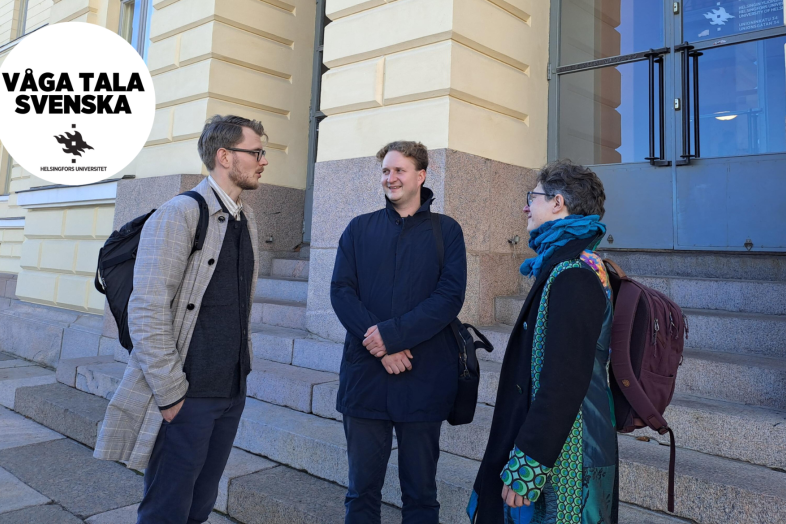 Tre personer stående utanför huvudbyggnaden. 