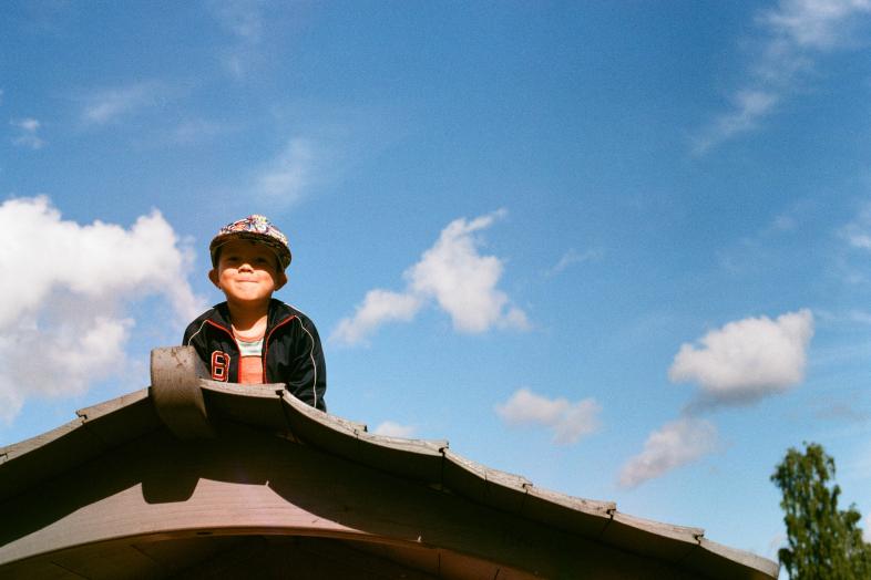 a smiling child with a blue sky as background