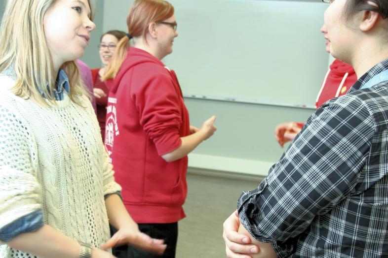 Opiskelijoita seisomassa luokkatilassa